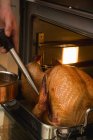 Basting turkey with roasting juices — Stock Photo