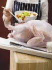 Female hands Stuffing turkey — Stock Photo