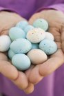 Mani che tengono uova di cioccolato — Foto stock