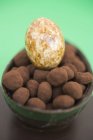 Nahaufnahme von Schokoladenei halb gefüllt mit kleinen Trüffeln und weißem Schokoladenei — Stockfoto