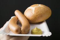 Sausages with mustard and roll of bread — Stock Photo