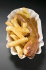 Currywurst with fried potato chips — Stock Photo