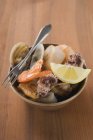 Closeup view of seafood with wedge of lemon and fork in bowl — Stock Photo