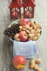 Red apples with almonds and cone — Stock Photo