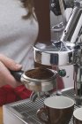Closeup view of woman holding filter holder of coffee machine — Stock Photo