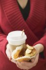 Woman holding muffin and cup of coffee — Stock Photo
