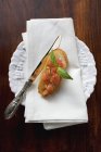 Bruschetta with fresh herbs on white plate with towel and knife — Stock Photo