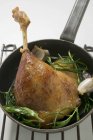 Fried goose leg with rosemary in frying pan — Stock Photo