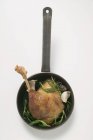 Top view of fried goose leg with rosemary in frying pan — Stock Photo