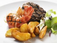 Beef steak and shrimp with fried potatoes — Stock Photo