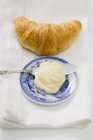 Croissant con mantequilla y cuchillo - foto de stock