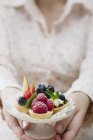 Closeup cropped view of woman holding tarts with berries — Stock Photo