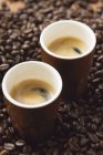 Espressotassen auf Kaffeebohnen — Stockfoto
