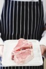 Шеф-повар держит свиные отбивные — стоковое фото