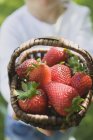 Mann hält Korb mit Erdbeeren — Stockfoto