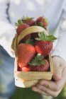 Homme tenant panier de fraises — Photo de stock