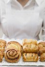 Cropped view of woman holding silver tray of assorted Danish pastries — Stock Photo