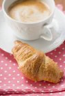 Croissant with cup of cappuccino — Stock Photo