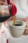 Frauenhände gießen Kaffee ein — Stockfoto