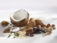 Closeup view of assorted nuts and chocolate on white surface — Stock Photo