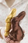 Manos femeninas sosteniendo conejos de Pascua - foto de stock