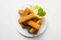 Deep-fried fish fingers with garnish — Stock Photo