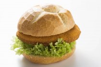 Poultry burger  with salad leaf laying on white surface — Stock Photo