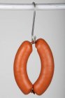Closeup view of ring Bologna sausages on a hook — Stock Photo