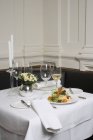 Insalata e vino bianco sulla tavola apparecchiata nel ristorante — Foto stock
