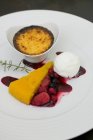 Крупный план смешанной десертной тарелки с кремовым брули, ягодами и мороженым — стоковое фото