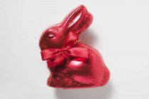 Conejo de chocolate en papel de aluminio rojo - foto de stock