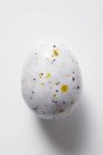 Primo piano vista dell'uovo di cioccolato maculato sulla superficie bianca — Foto stock