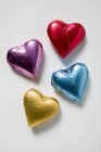 Coeurs de chocolat en feuille colorée — Photo de stock