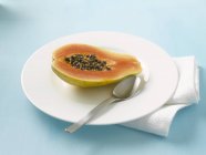 Половина свежей папайи в тарелке — стоковое фото