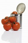 Opened tomato tin with fresh tomatoes — Stock Photo