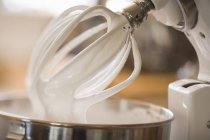 Closeup view of whipped cream on balloon whisk of food mixer — Stock Photo