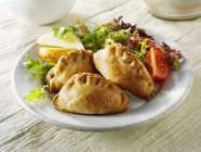 Closeup view of pasties with vegetable salad — Stock Photo