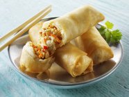 Closeup view of whole and broken Spring rolls with chopsticks — Stock Photo