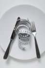 Vista dall'alto del coltello con forchetta e metro a nastro su piastra bianca — Foto stock