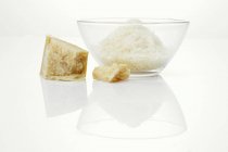 Piece of Parmesan in glass bowl — Stock Photo