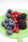 Fresh berries on green strainer — Stock Photo