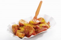 Salchicha con ketchup y curry en polvo - foto de stock