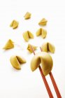 Closeup view of fortune cookies and chopsticks on white background — Stock Photo