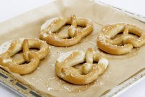 Four pretzels on a baking tray — Stock Photo
