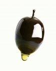Olivenöl, das von einer Olive tropft — Stockfoto