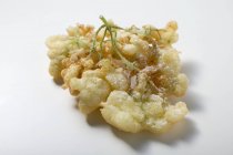 Primo piano vista di frittelle di fiori di sambuco sulla superficie bianca — Foto stock
