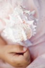 Closeup cropped view of child hand by sea shell — Stock Photo