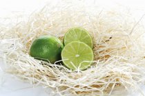 Limes fraîches mûres en paille — Photo de stock