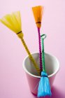 Closeup view of three colored pastry brushes in pink beaker — Stock Photo