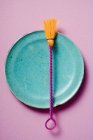Closeup top view of colored pastry brush on blue plate — Stock Photo